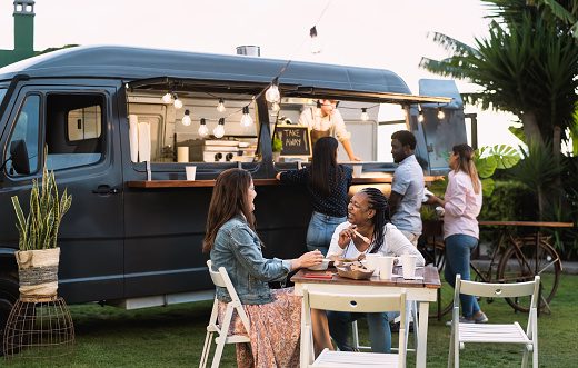 People having fun eating in a street food truck.