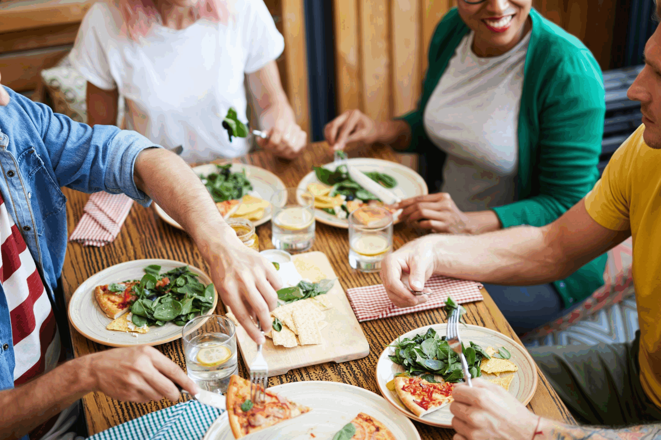 At an allergy friendly restaurant in Franklin, TN, a group of friends gather around a meal of greens and pizza.